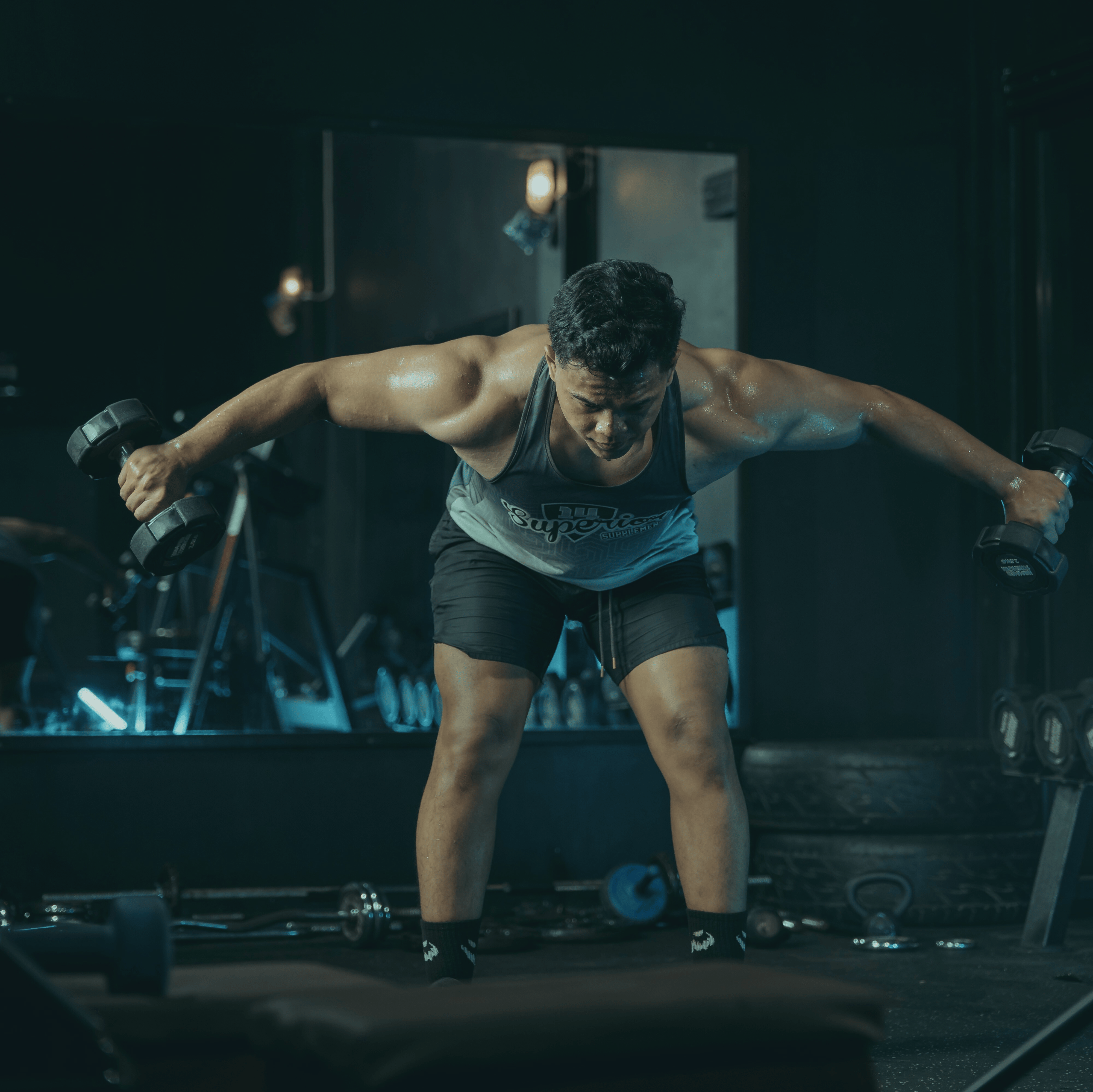Person exercising with dumbbells in a gym setting