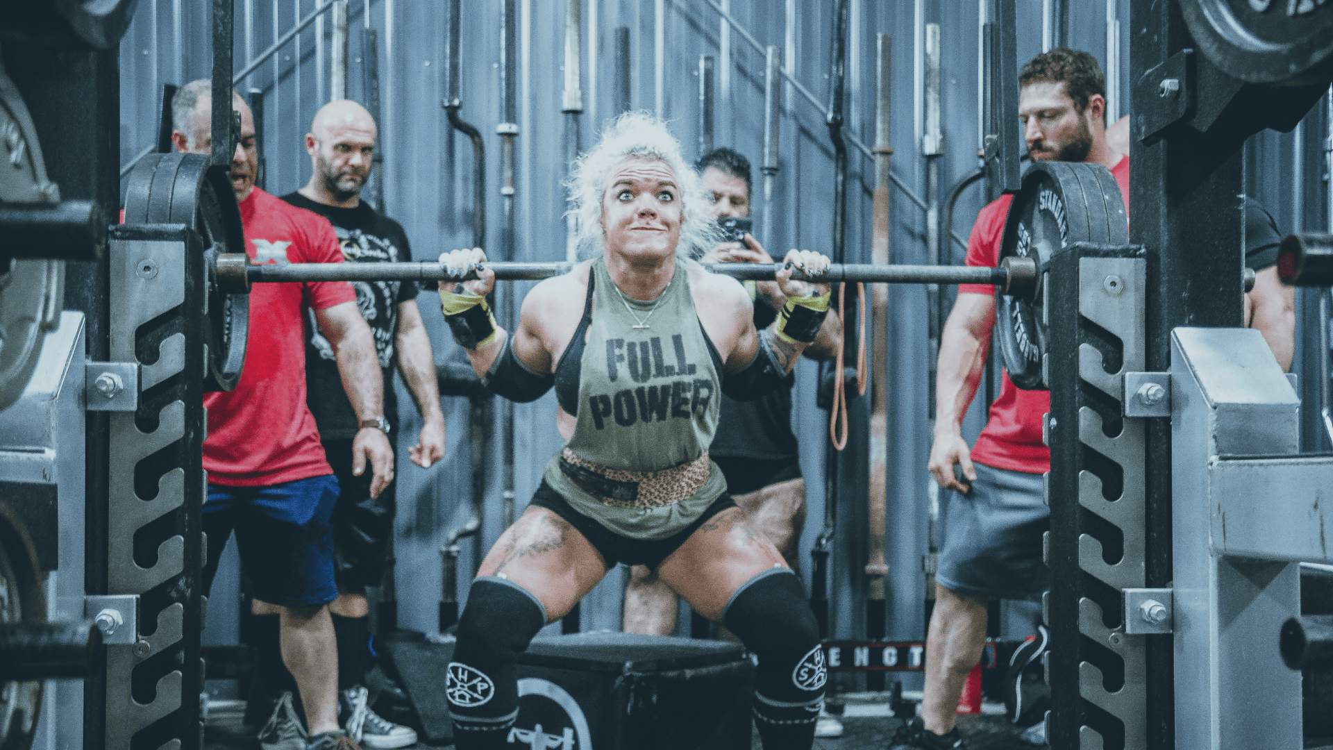 Person lifting weights with 'Full Power' tank top in a gym setting