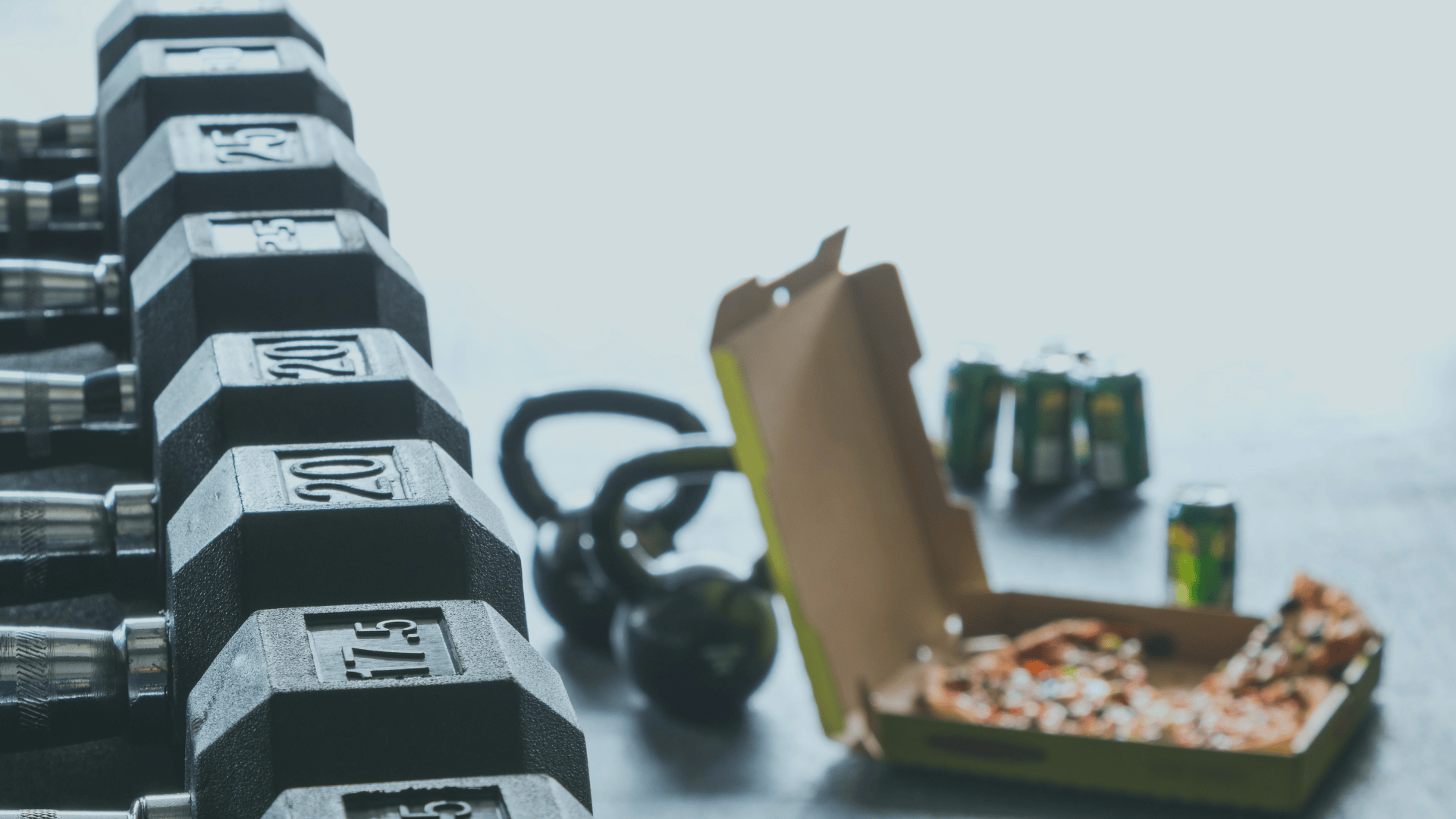 Stack of dumbbells, kettlebell, and a pizza with soda